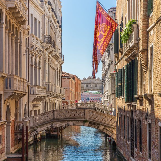 A vertical shot of a canal with bridge in Venice, Italy